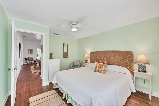 a bedroom with a bed and wooden floor