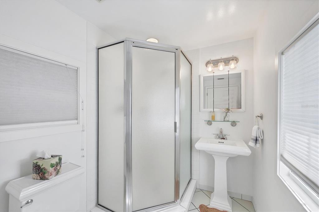 380 Tarpon Avenue Boca Grande, FL 33921 - Photo 21 of 38 a bathroom with a sink shower and a mirror