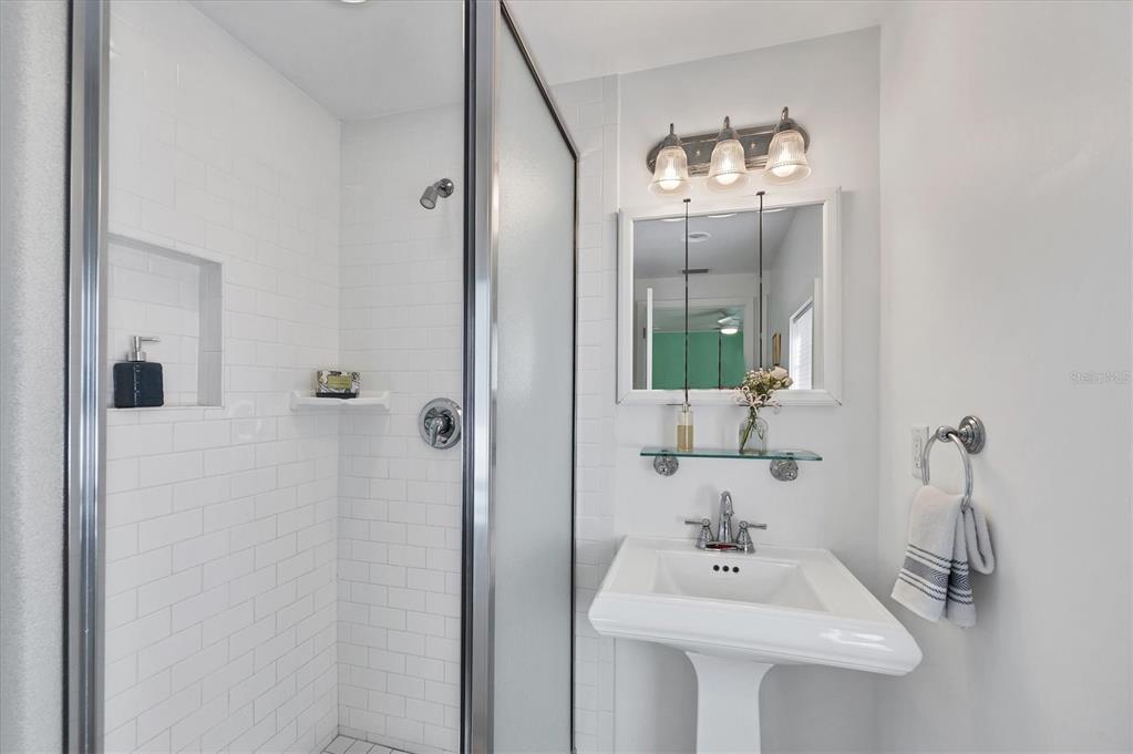 380 Tarpon Avenue Boca Grande, FL 33921 - Photo 22 of 38 a bathroom with a sink a mirror and shower