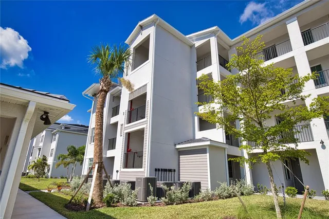 a front view of a multi story residential apartment building with yard