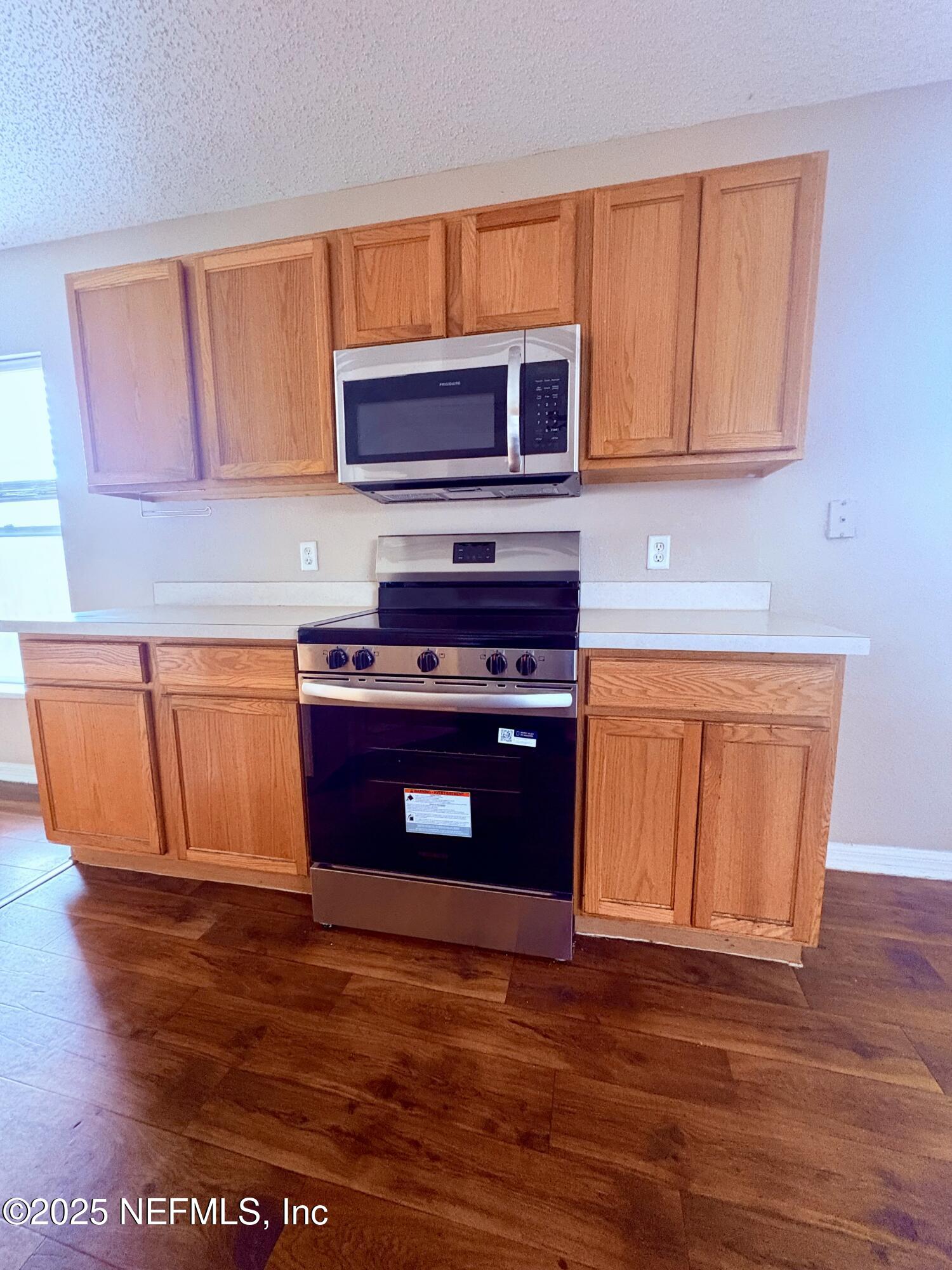 2996 Valkyrie Road Middleburg, FL 32068 - Photo 2 of 9 a kitchen with stainless steel appliances granite countertop a stove a sink and a microwave