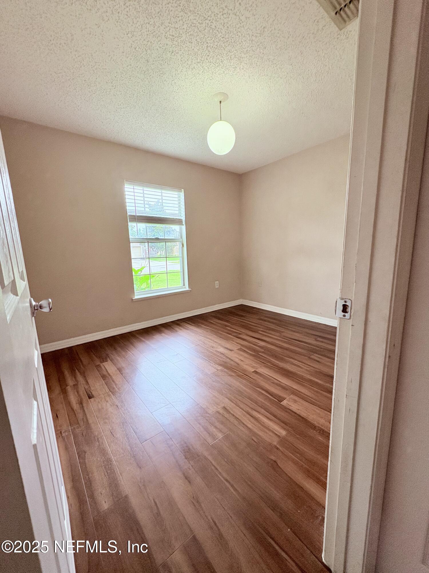 2996 Valkyrie Road Middleburg, FL 32068 - Photo 7 of 9 an empty room with wooden floor and windows