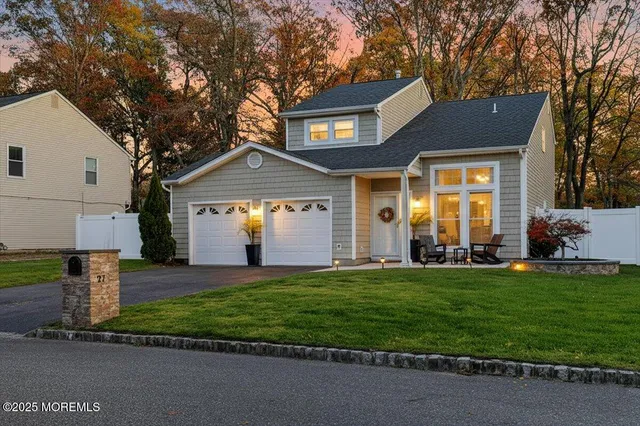 a front view of a house with a yard and trees