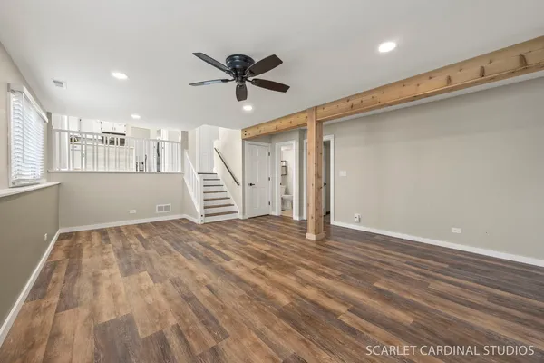 a view of empty room with wooden floor and window