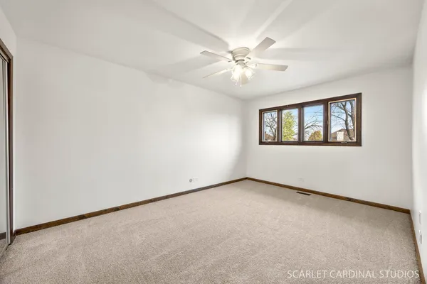 an empty room with windows and fan