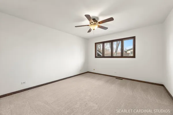 a view of a big room with windows and chandelier fan