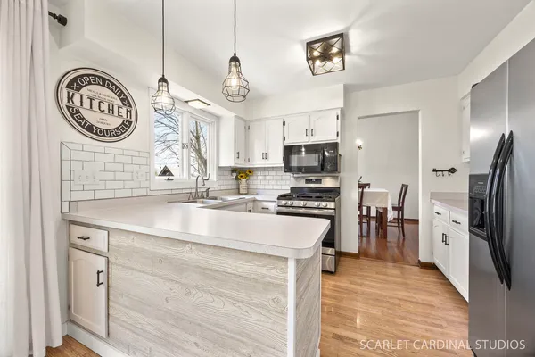 a kitchen with kitchen island a counter space a clock and cabinets