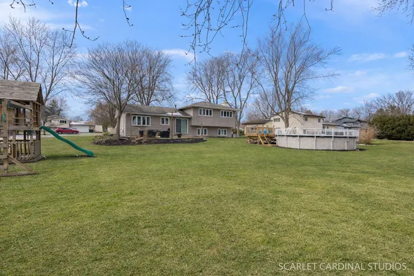 a view of a house with a big yard and large trees