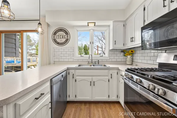 a kitchen with stainless steel appliances white cabinets and a sink