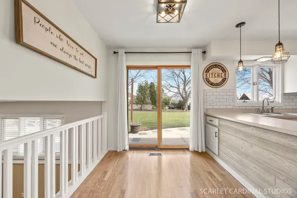 a view of a hallway to window and wooden floor