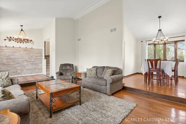 a living room with furniture dining table and a chandelier