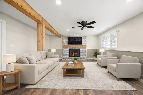 a living room with furniture a fireplace and a flat screen tv