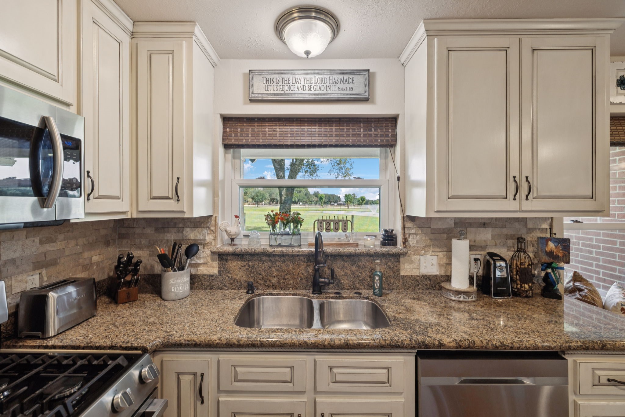 31229 Rochen Road Waller, TX 77484 - Photo 13 of 50 a kitchen with granite countertop a sink a stove and cabinets