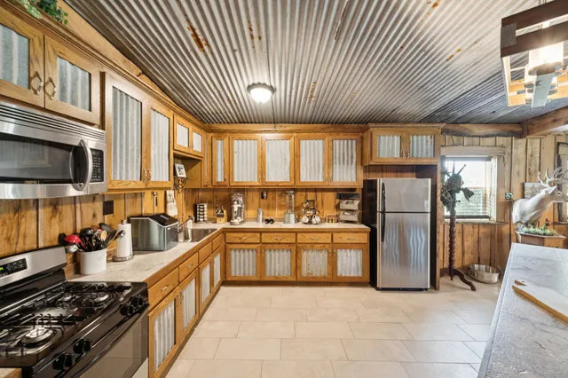 a kitchen with stainless steel appliances granite countertop a refrigerator and a stove