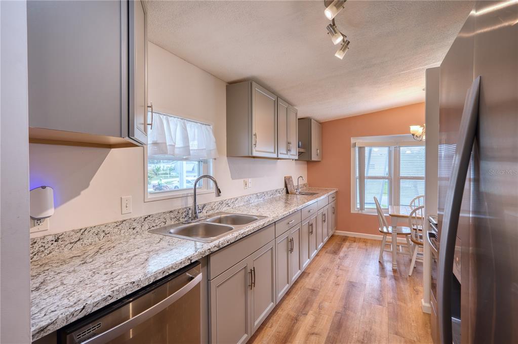 6269 Parakeet Road Englewood, FL 34224 - Photo 2 of 28 a kitchen with granite countertop a sink stove and cabinets