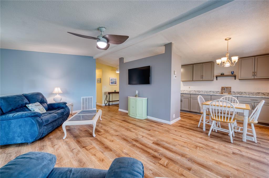 6269 Parakeet Road Englewood, FL 34224 - Photo 7 of 28 a living room with furniture a flat screen tv and kitchen view