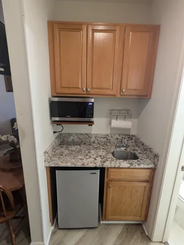 a kitchen with granite countertop a sink stove and cabinets