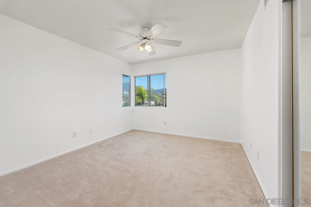 1819 Monarch Ridge Circle El Cajon, CA 92019 - Photo 42 of 60 an empty room with a chandelier fan and windows