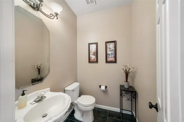 a bathroom with a sink mirror and toilet