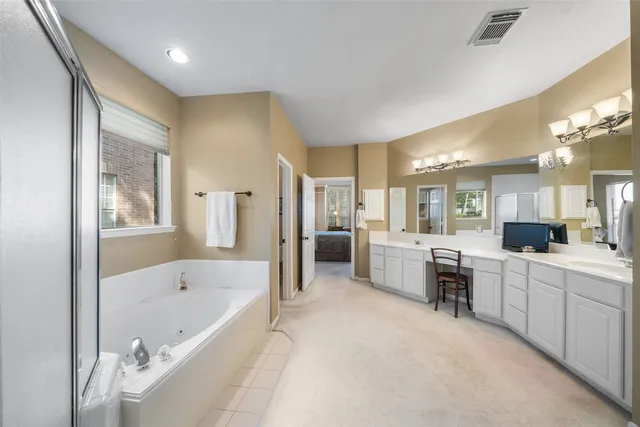 a large spacious bathroom with a large tub shower and sink