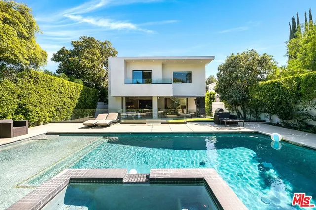 a view of a house with swimming pool and sitting area