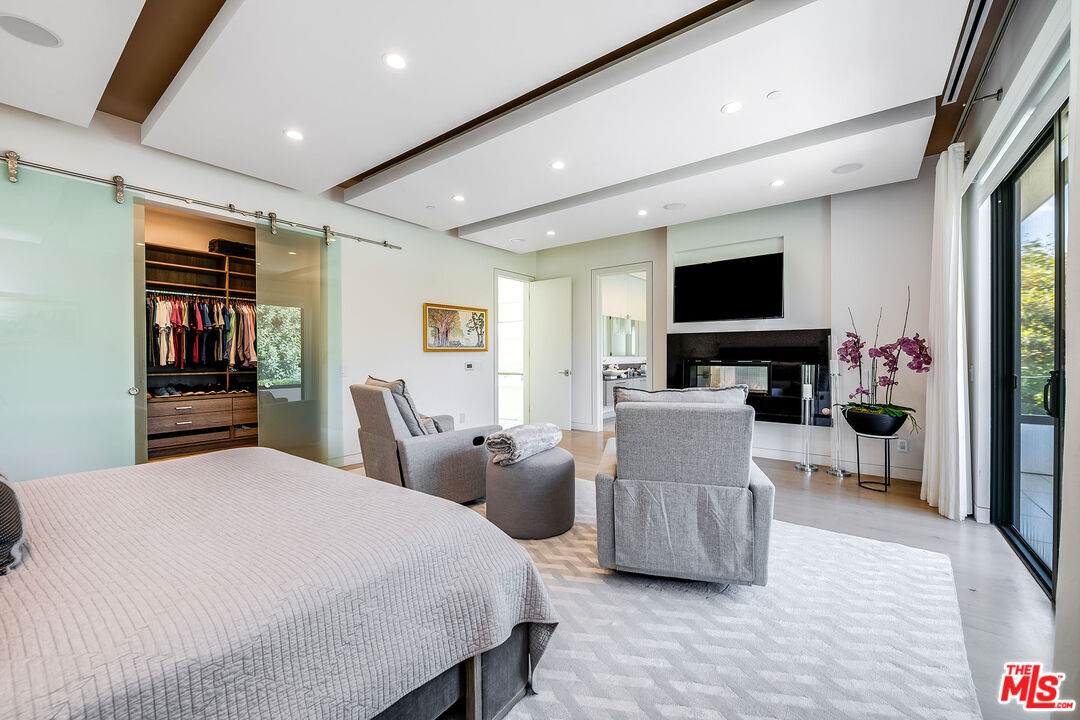 5101 Rubio Avenue Encino, CA 91436 - Photo 17 of 23 a bedroom with furniture a flat screen tv and a book shelf