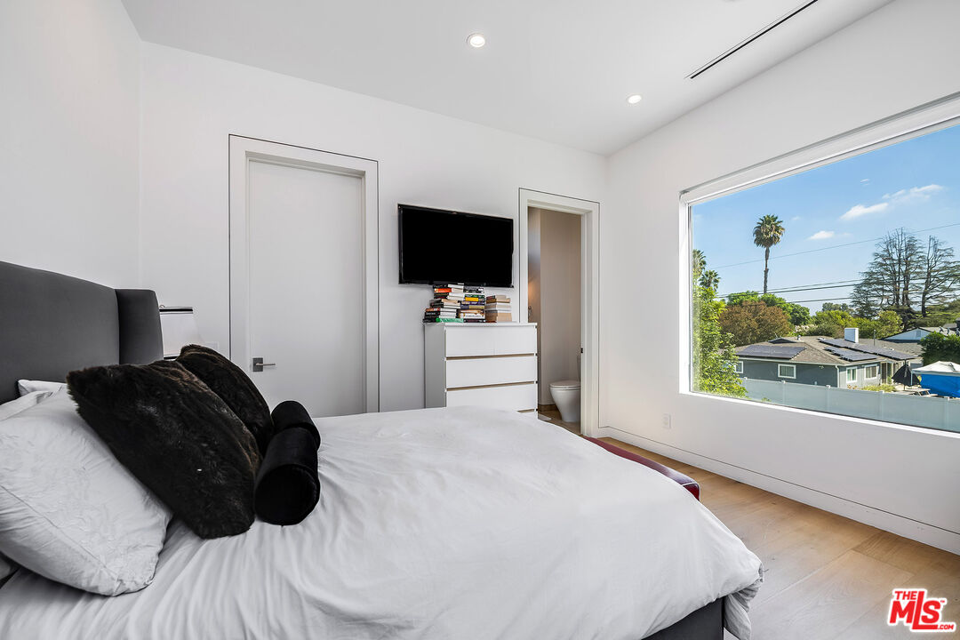 5101 Rubio Avenue Encino, CA 91436 - Photo 20 of 23 a bedroom with a bed and a flat tv screen on the dresser