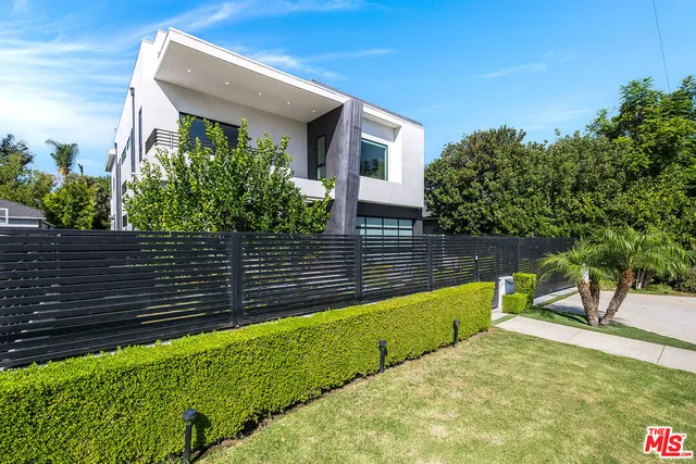 a front view of a house with a garden and yard