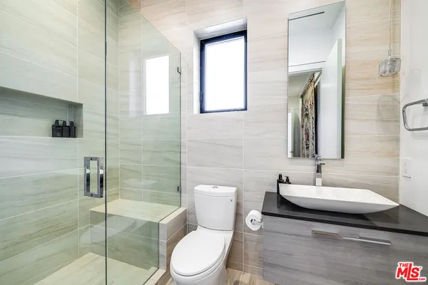 a bathroom with a toilet a sink and mirror