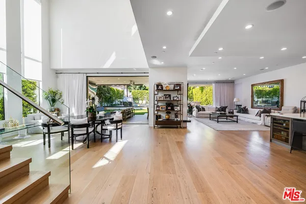 a living room with furniture a wooden floor and a large window