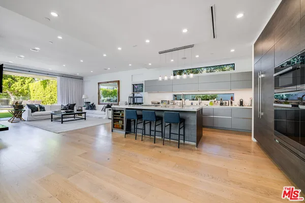 a kitchen with stainless steel appliances lots of counter space and furniture