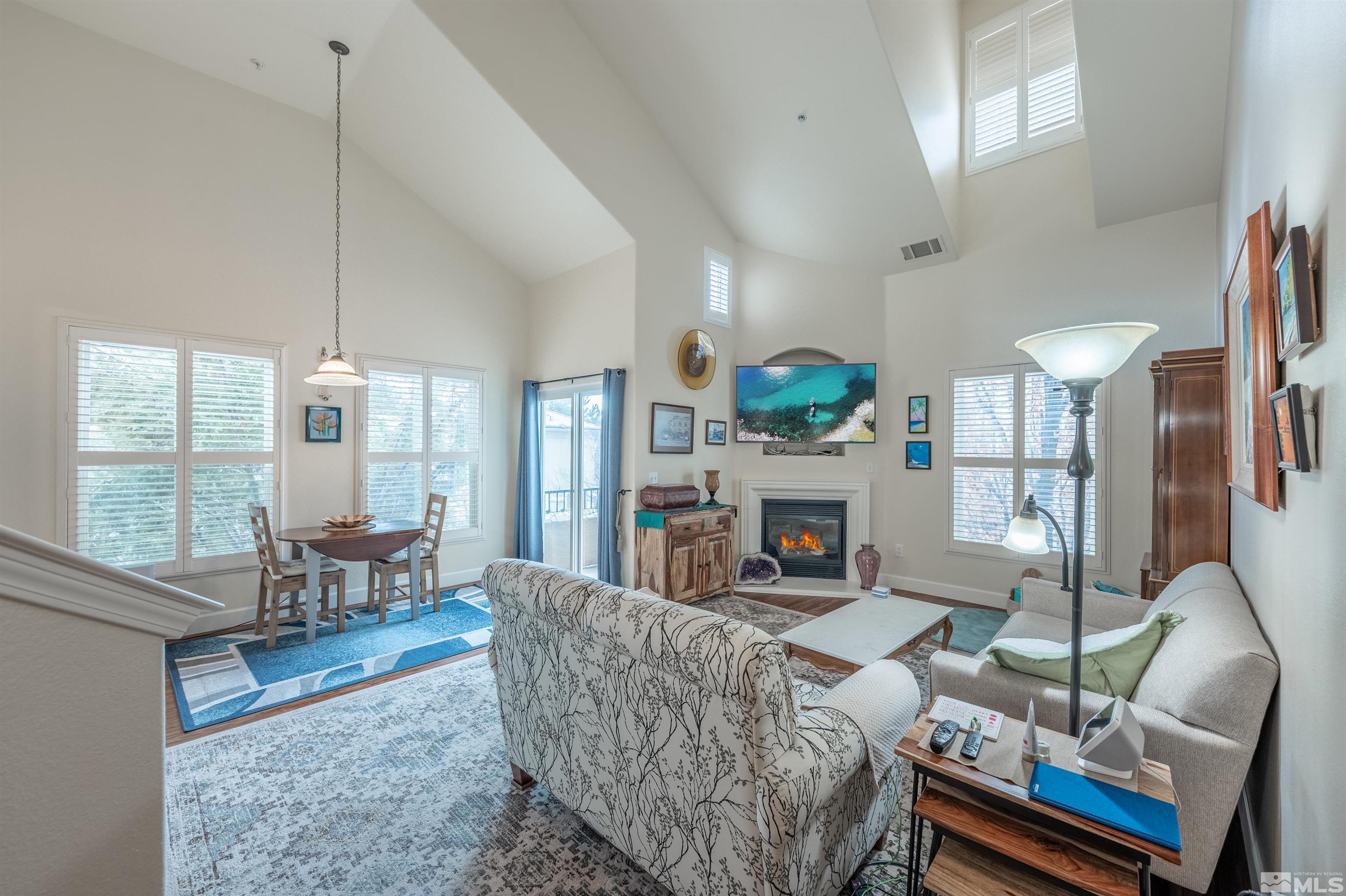 9050 Double R Boulevard, Unit 1925 Reno, NV 89521 - Photo 1 of 32 a living room with furniture a fireplace and a floor to ceiling window