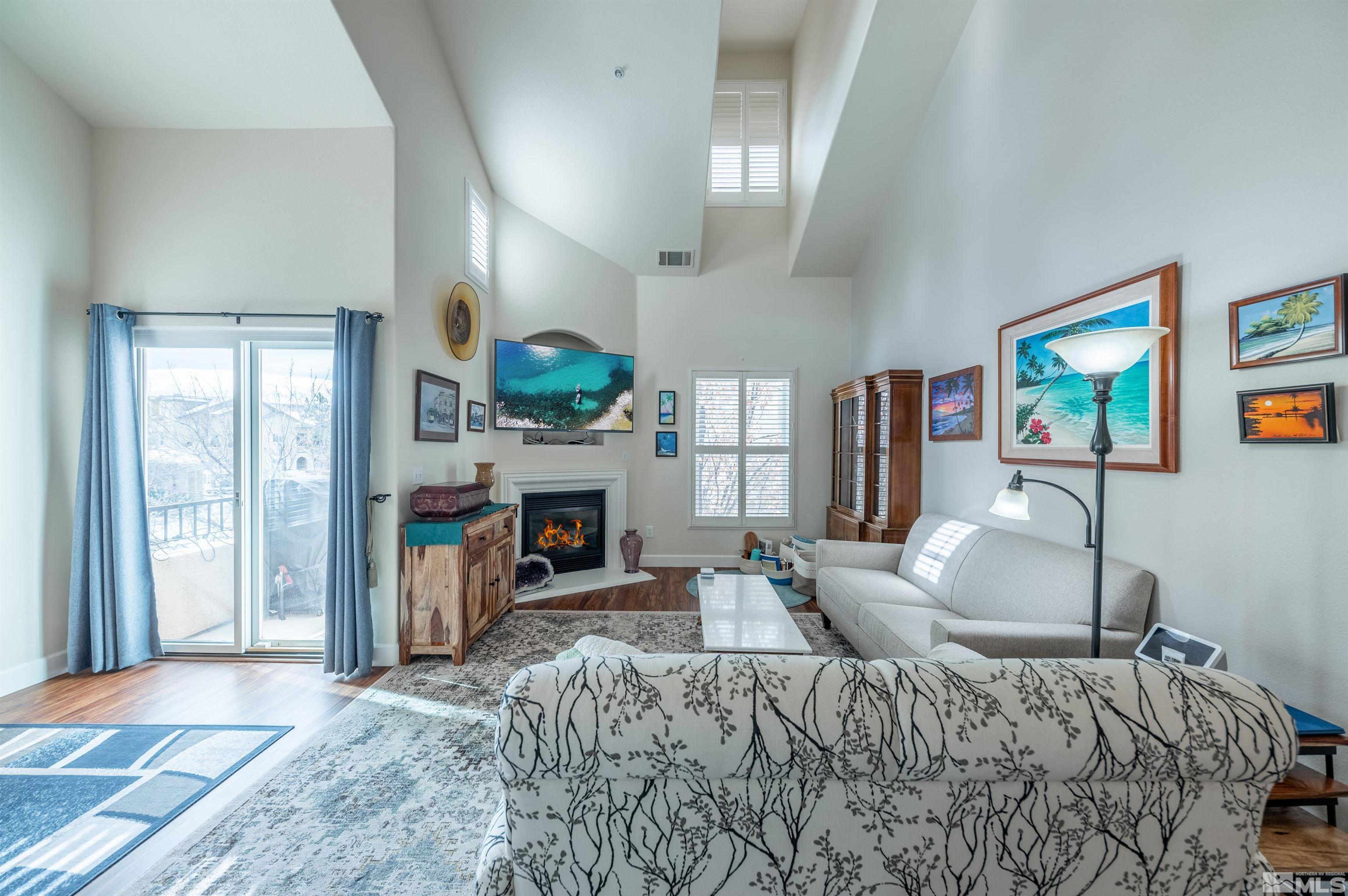 9050 Double R Boulevard, Unit 1925 Reno, NV 89521 - Photo 2 of 32 a bedroom with furniture a fireplace and a window