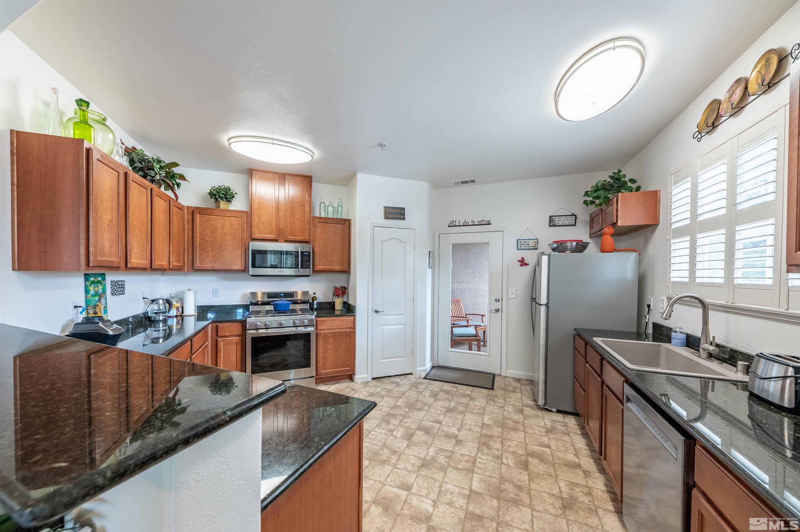 9050 Double R Boulevard, Unit 1925 Reno, NV 89521 - Photo 7 of 32 a kitchen with stainless steel appliances granite countertop a sink stove and refrigerator