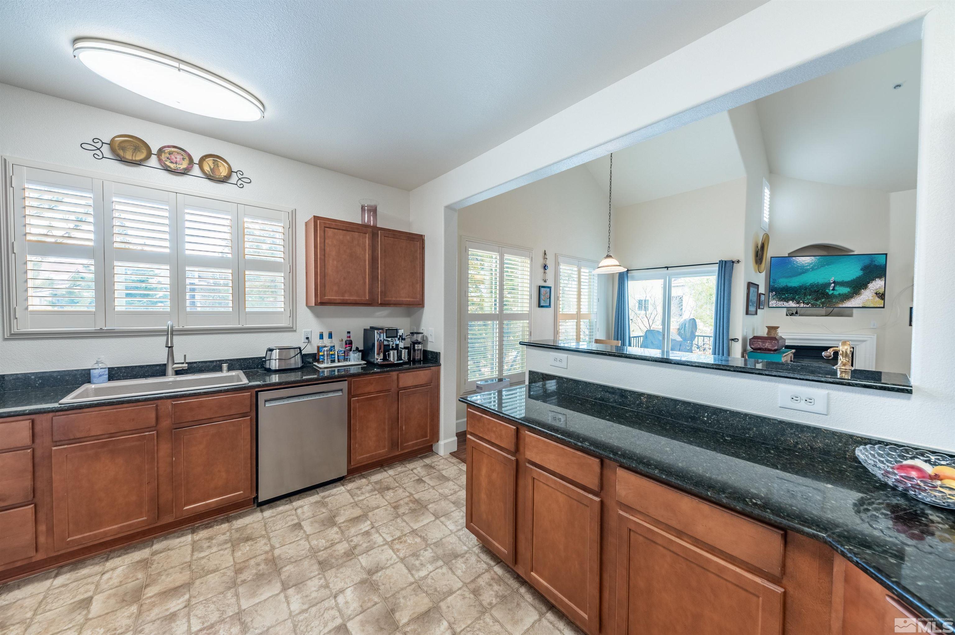 9050 Double R Boulevard, Unit 1925 Reno, NV 89521 - Photo 8 of 32 a large kitchen with granite countertop stainless steel appliances a sink counter space and a window
