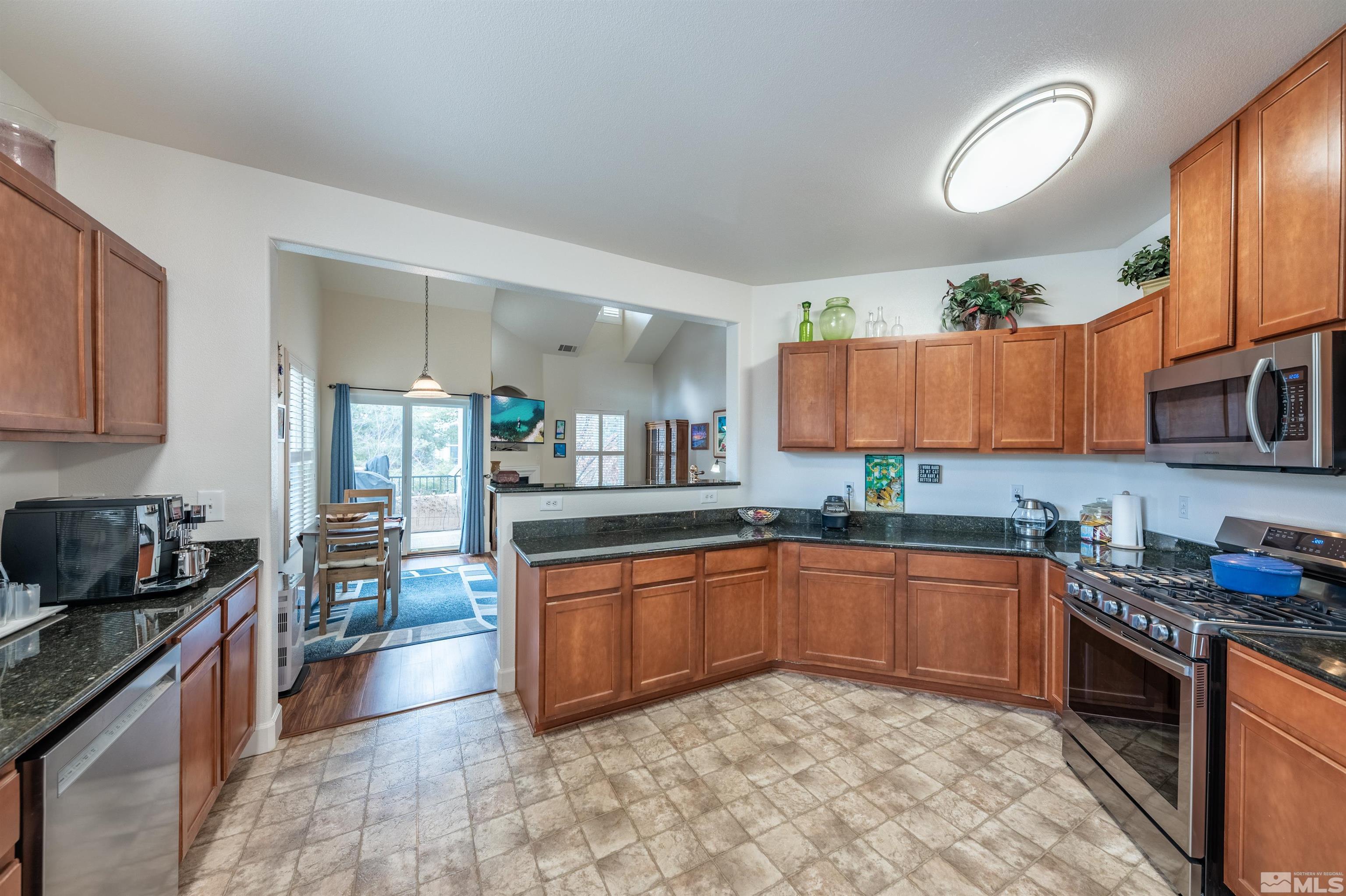 9050 Double R Boulevard, Unit 1925 Reno, NV 89521 - Photo 10 of 32 a kitchen with stainless steel appliances granite countertop a sink stove and cabinets