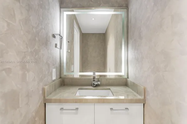 a bathroom with a granite countertop sink and a mirror