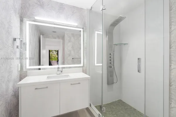 a bathroom with a shower sink and mirror