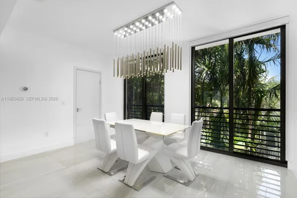 a dining room with furniture and large windows