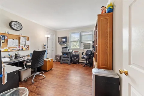 a view of a workspace with furniture and a window