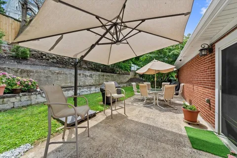 a view of a patio with table and chairs under an umbrella