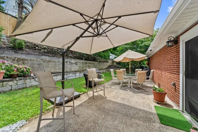 a view of a patio with table and chairs under an umbrella