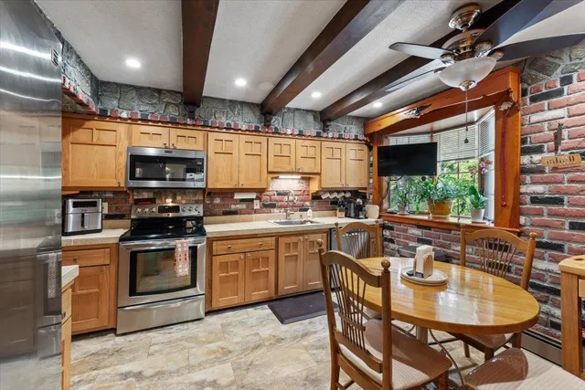 a kitchen with sink a microwave and chairs