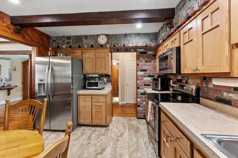 a kitchen with stainless steel appliances granite countertop a refrigerator a stove and a sink