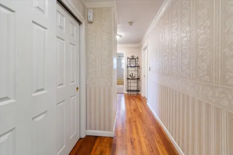 a view of a hallway with wooden floor and staircase