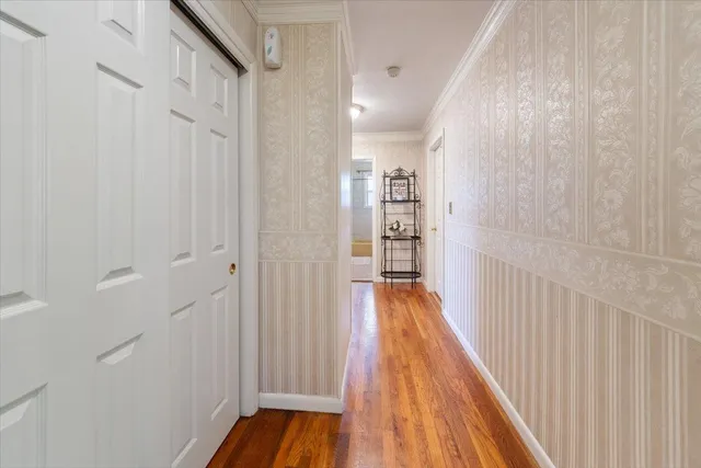 a view of a hallway with wooden floor and staircase
