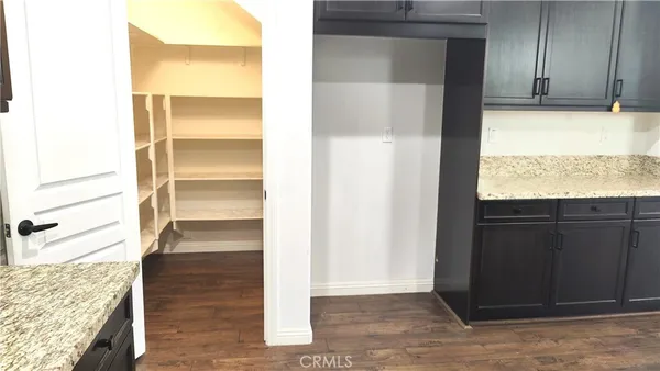 a view of walk in closet with wooden floor