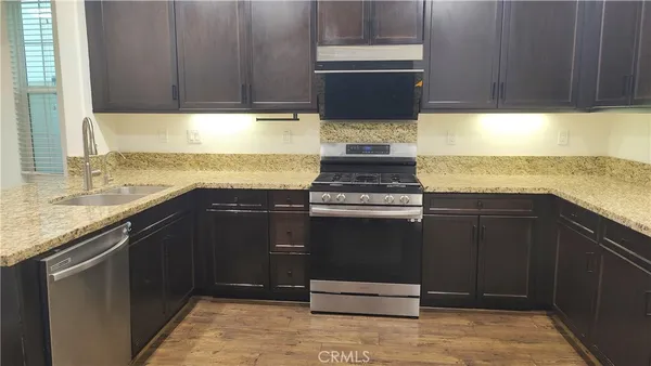 a kitchen with granite countertop a stove and a sink
