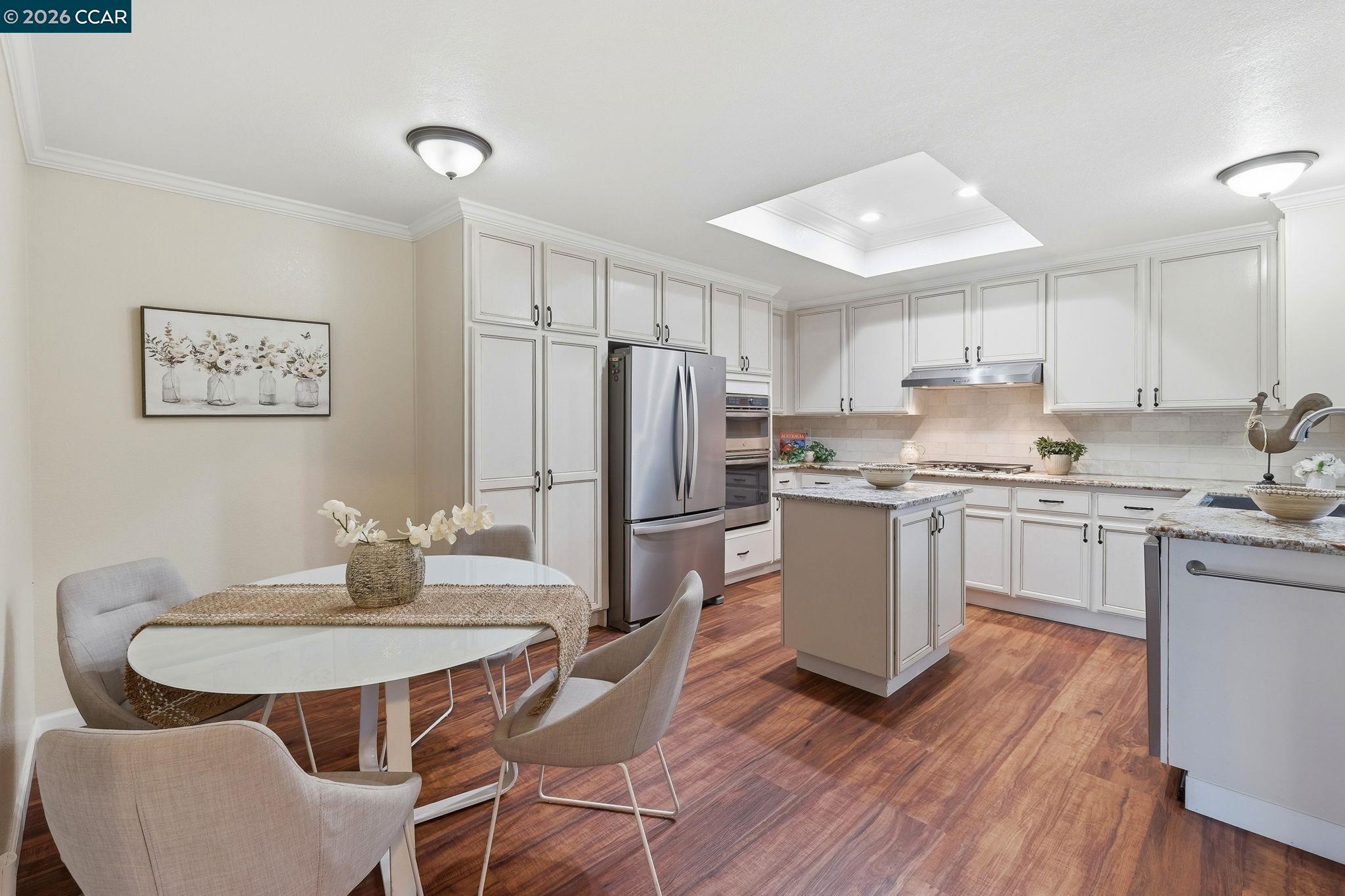1707 Geary Road Walnut Creek, CA 94597 - Photo 12 of 43 a kitchen with a dining table chairs refrigerator and wooden floor