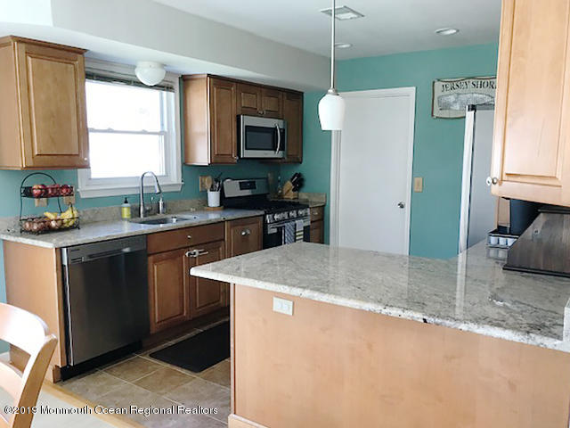 50 Sweet Gum Road Howell, NJ 07731 - Photo 2 of 18 a kitchen with stainless steel appliances granite countertop a sink a stove a refrigerator a microwave oven with white cabinets and wooden floor